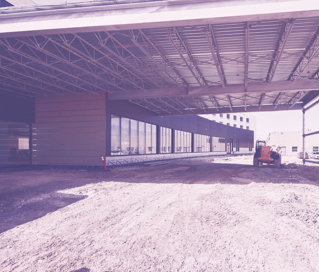 Hotel entrance during construction phase with heavy machinery in background.