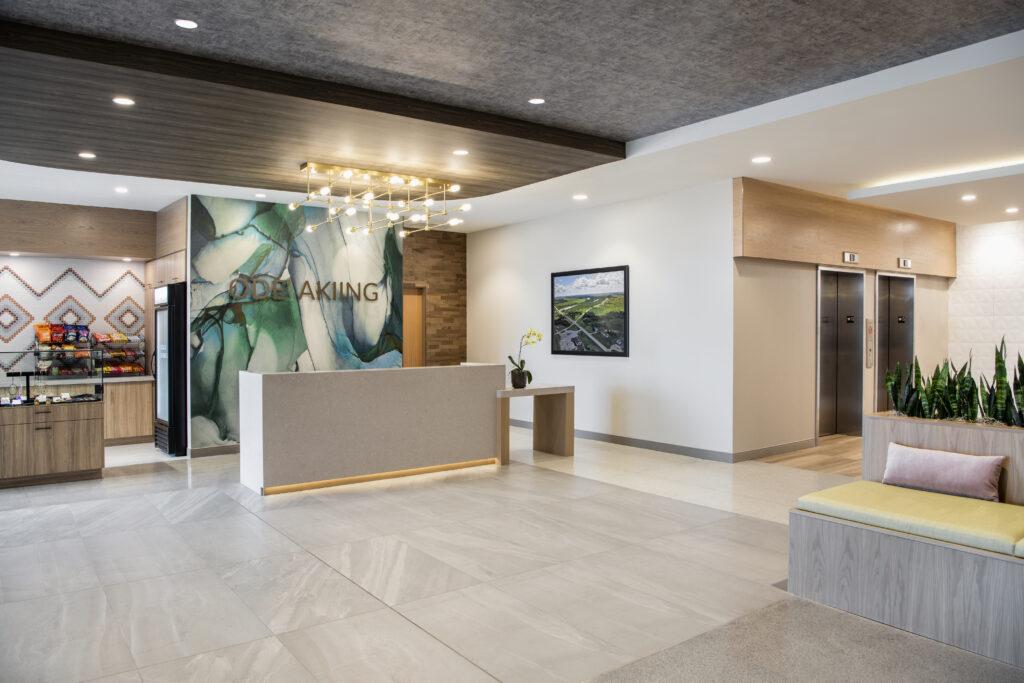 Hotel reception desk with marble wall behind and large lighting fixture